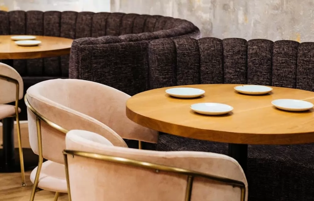 Ημικυκλικά booths σε εστιατόριο, και τραπέζια με τέσσερα πιάτα επάνω