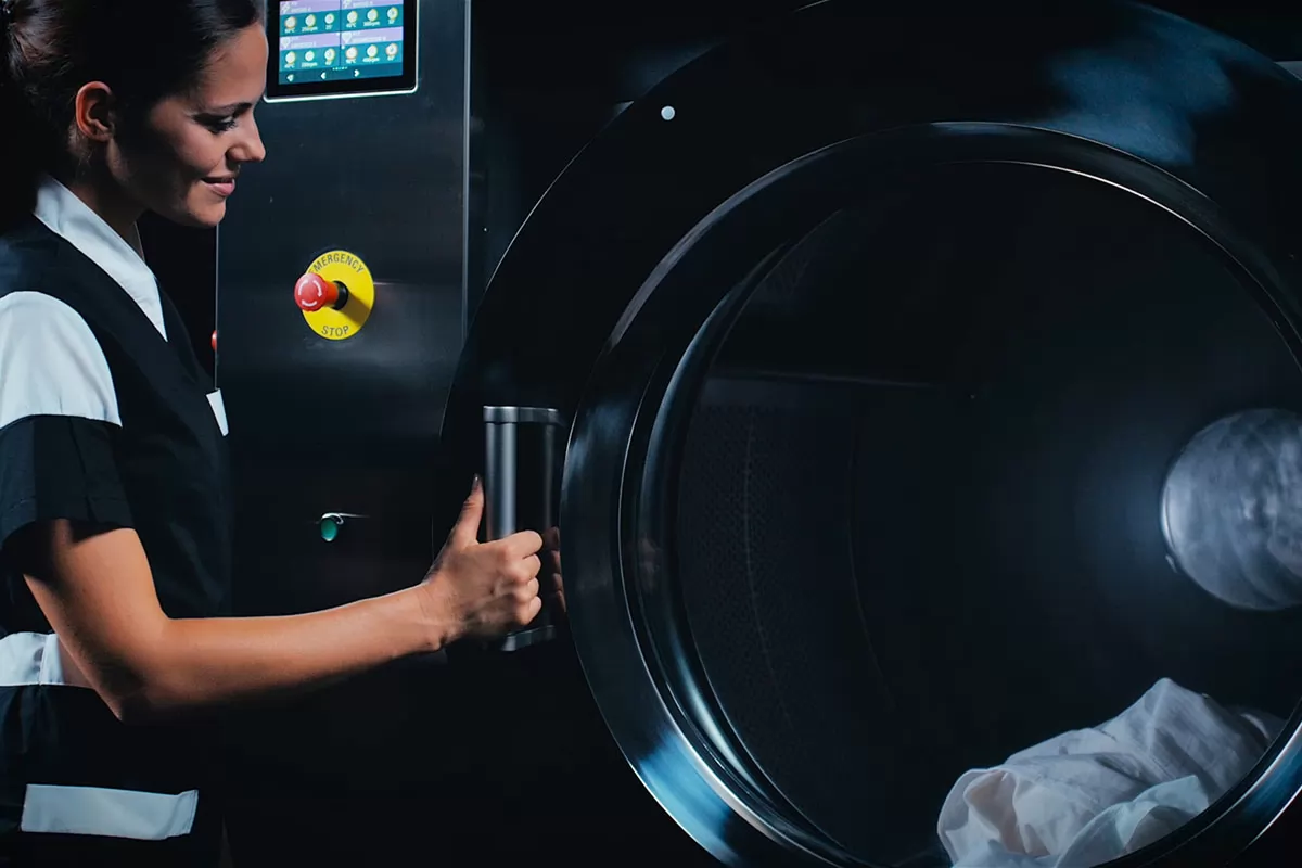 Γυναίκα μπροστά από ένα επαγγελματικό πλυντήριο ρούχων της IMESA