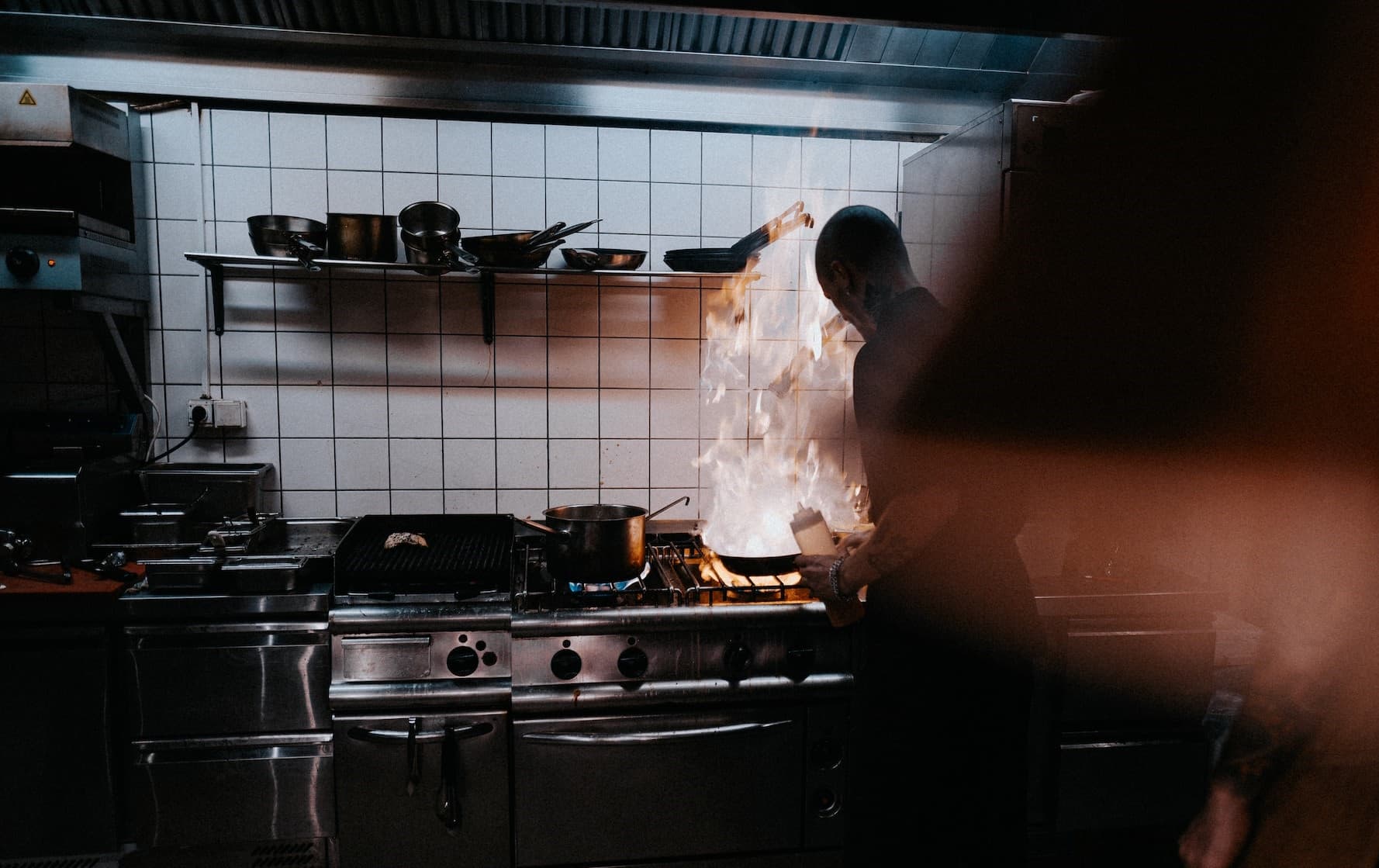 Άνδρας σεφ σε επαγγελματική κουζίνα εστιατορίου με ανοξείδωτες κατασκευές